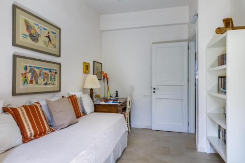 a living room with a white couch and a desk at Skopelos Village Hotel in Skopelos Town