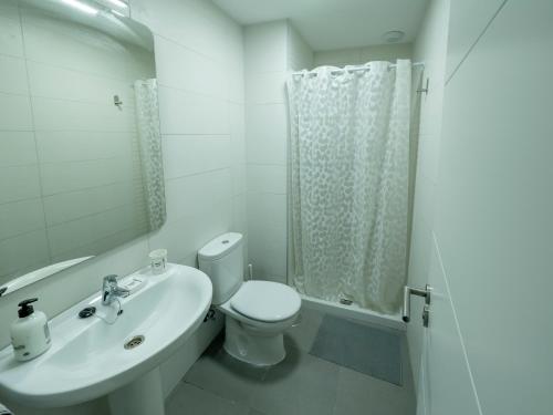 a white bathroom with a toilet and a sink at La Ermita FjHomeFj in Jerez de la Frontera