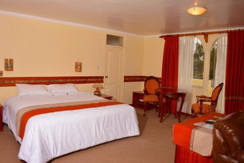 a hotel room with a bed and a table and chairs at Taypikala Lago in Puno