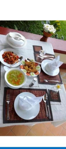 a table with white plates of food on it at Rivergarden Guesthouse and restaurant in Don Det