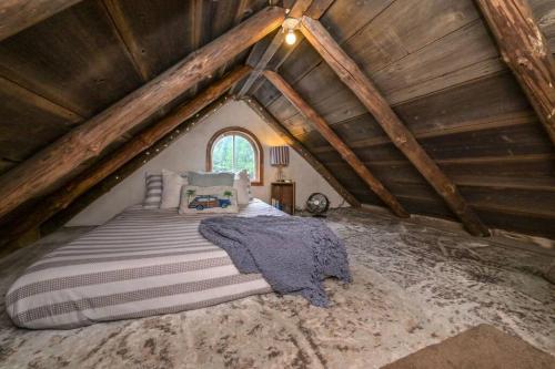 1 dormitorio con 1 cama en el ático en A rustic cabin in the woods, en Orangeville