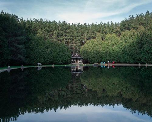 a small house on the shore of a lake at A rustic cabin in the woods in Orangeville