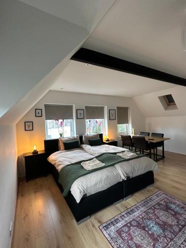 um quarto com uma cama grande e uma mesa em D10 Apartments em Breda