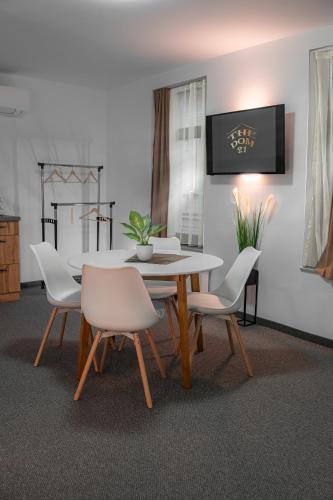 a dining room with a table and white chairs at The Dom 21 in Cluj-Napoca