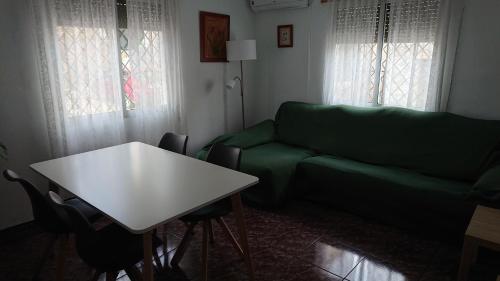 ein Wohnzimmer mit einem grünen Sofa und einem Tisch in der Unterkunft La Casa de Vicente y Soledad in Ruidera