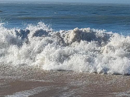 a wave crashing on the beach in the ocean at Village Vacances Bonne Anse Plage in La Palmyre