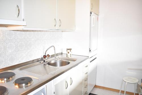 a kitchen with white cabinets and a sink at Astoria (213 Le) in Lenzerheide