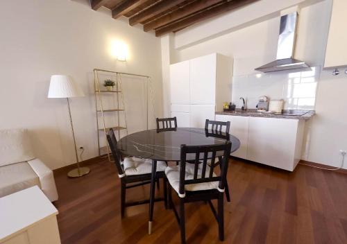 a dining room with a table and chairs and a kitchen at ISA Granada in Granada