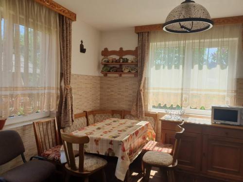 a dining room with a table and chairs and windows at Casa Rustic in Vama