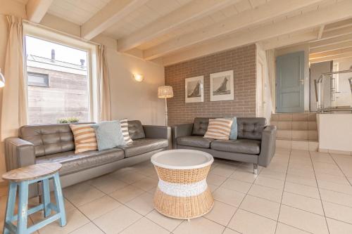 a living room with two couches and a table at Op t land 25 in Callantsoog