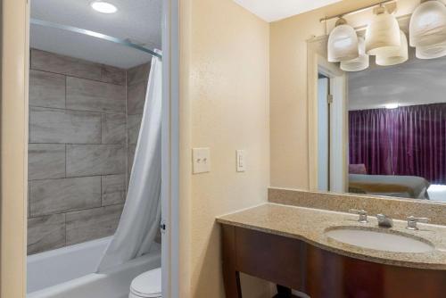 a bathroom with a sink and a tub and a toilet at Rodeway Inn Colonial Heights I-95 in Colonial Heights