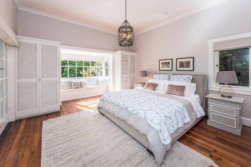 a bedroom with a large bed and a chandelier at Kerrisdale Bowral in Bowral