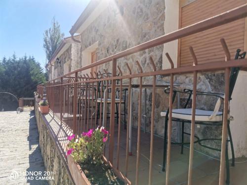 a balcony of a house with chairs and flowers at Hotel Sierra Oriente in Guadarrama