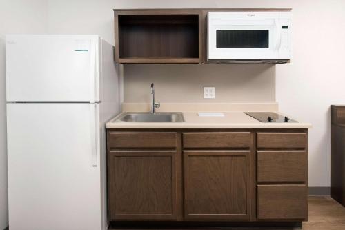 a kitchen with a sink and a white refrigerator at WoodSpring Suites Chicago Tinley Park in Tinley Park