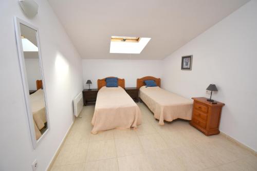 Balcon del MarにあるApartamento Menorcaのベッドルーム1室(ベッド2台、鏡付)