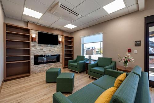 a waiting room with a couch and chairs and a fireplace at Comfort Suites Colorado Springs East - Medical Center Area in Colorado Springs