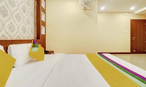 a bedroom with a white bed with a colorful blanket at Itsy Hotels Sapphire Residency in Manjeri