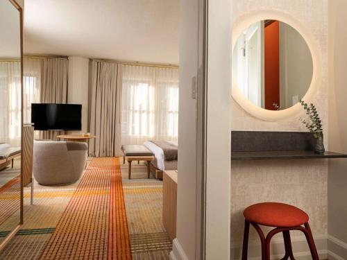 a hotel room with a large mirror on the wall at Hotel Andra Seattle MGallery Hotel Collection in Seattle