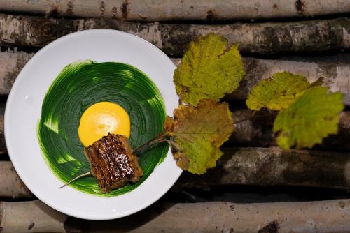 a plate with a piece of meat and an egg at VILLA HUNDERT Boutique Mountainscape in Engelberg