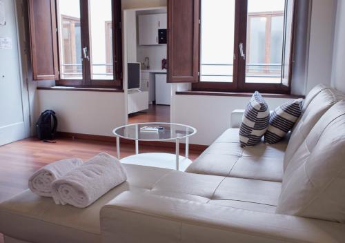 sala de estar con sofá blanco y mesa en ISA Granada, en Granada