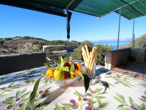 - un bol de fruits et de légumes sur une table sur un balcon dans l'établissement Green Area Stone House, à Vela Luka