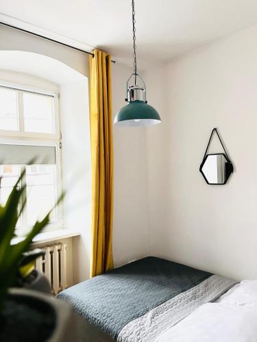 a bedroom with a bed and a hanging lamp at Narutowicza 5 Apartments in Inowrocław