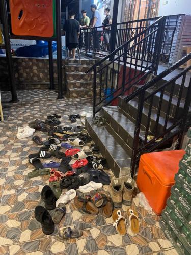a pile of shoes on the floor next to stairs at 15PAX 3 BR, Kids Swimming Pool, Pool table, BBQ near Spice ARENA, Airport Penang in Bayan Lepas