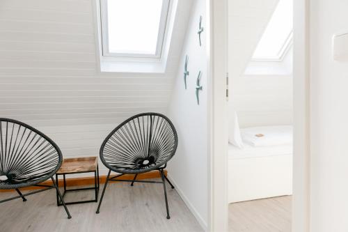 two chairs and a table in a room at Hotel Bethanien in Langeoog