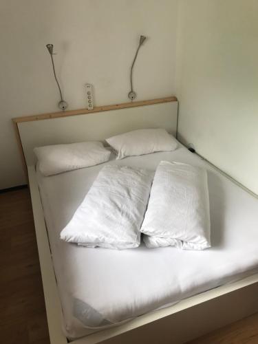 a white bed with four pillows on it at Sportpension Christina by PiaundDirk in Fügen