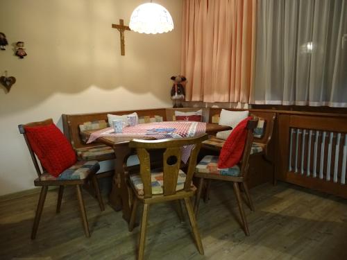 a dining room with a table and chairs with a cross at Sportpension Christina by PiaundDirk in Fügen