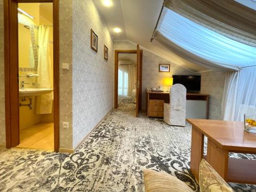 un soggiorno con lavandino e scrivania di Penthouse Apartment in Hotel Eney a Lviv