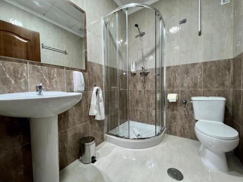 een badkamer met een douche, een toilet en een wastafel bij Hostal Kaizen in La Nucía