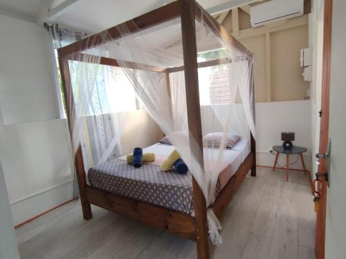 a small bedroom with a bed with a canopy at Bungalow Ti Papiyon in Bouillante