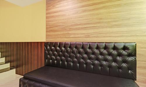 a leather bench in a bar with wood at Itsy Hotels Sapphire Residency in Manjeri