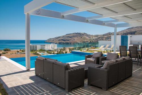 a patio with chairs and a swimming pool with a view at Blue Horizon 2 in Líndos