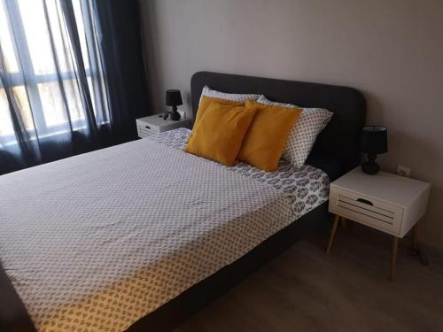 a bedroom with a bed with yellow pillows and a window at Apartment Opalchenska / Pirotska in Sofia