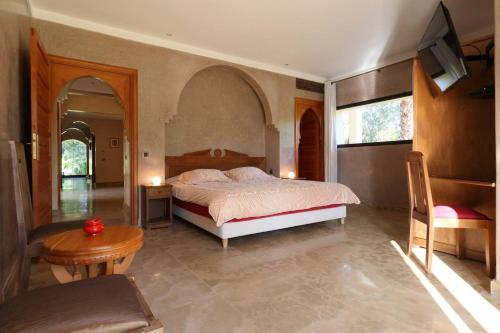 - une chambre avec un lit, une table et une chaise dans l'établissement Villa Pepe, à El Harkat