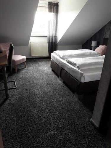 a hotel room with two beds and a window at Seehotel Losheim in Losheim