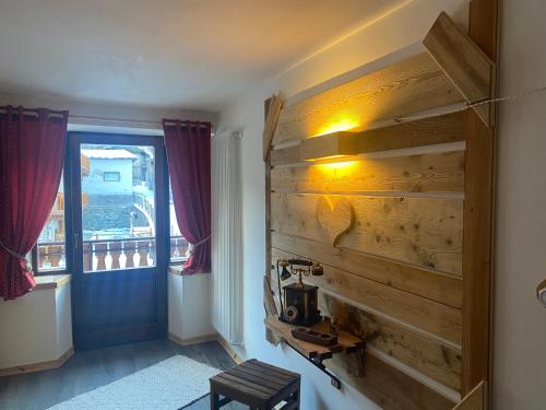 a room with a wooden wall and a window at Maison Rongier Mountain apartment COGNE Centro in Cogne