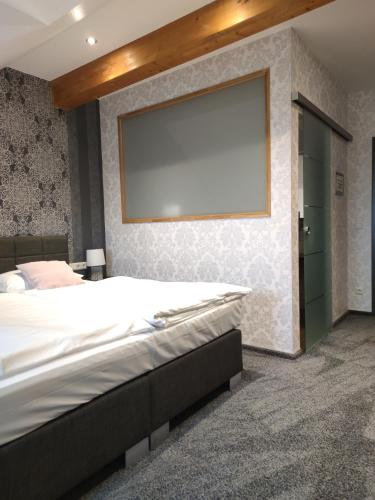 a bedroom with a large bed and a large projection screen at Seehotel Losheim in Losheim