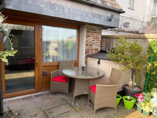 a patio with a table and chairs and a grill at Sawyers Bed and Breakfast in Looe
