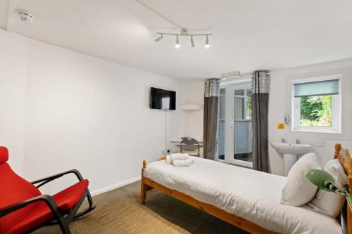a bedroom with a bed and a chair and a sink at Dover Town Rooms - Short Lets & Serviced Accommodation - Dover in Dover