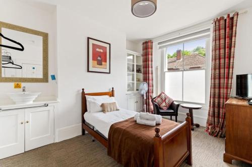 um quarto com uma cama, um lavatório e uma janela em Dover Town Rooms - Short Lets & Serviced Accommodation - Dover em Dover