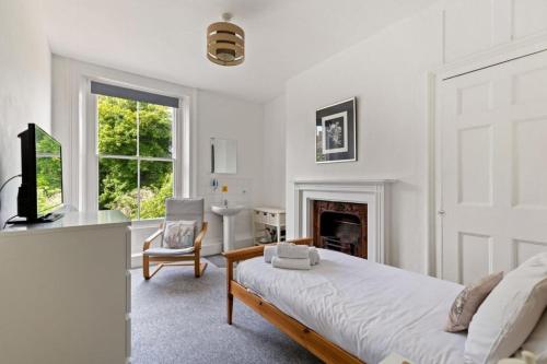 um quarto branco com uma cama e uma lareira em Dover Town Rooms - Short Lets & Serviced Accommodation - Dover em Dover