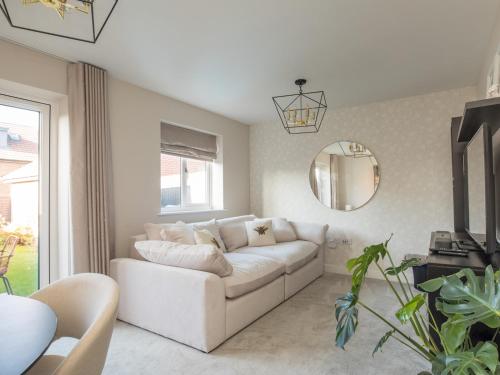a living room with a white couch and a mirror at Serene Home in Leafy Warfield w Private Garden - Pass the Keys in Bracknell