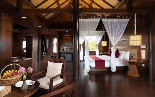 1 dormitorio con 1 cama, mesa y sillas en Mane Hariharalaya, en Siem Reap