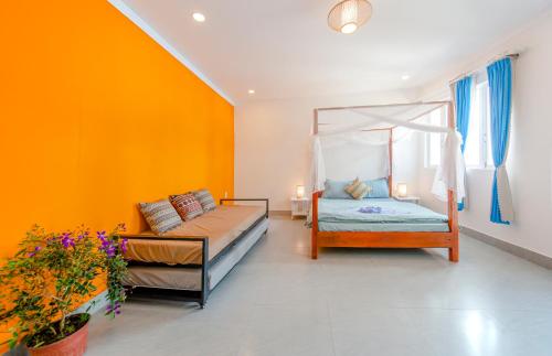 a bedroom with two beds and a couch at Homestay Vuon Phap BMT in Buon Ma Thuot