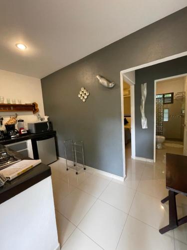 a kitchen with a gray wall and a white tile floor at Tamarindo Sunshine in Tamarindo