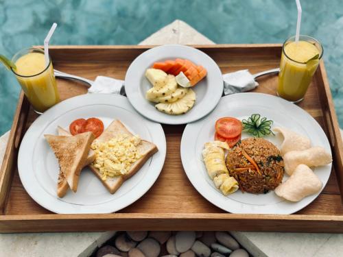 a tray with three plates of food and two drinks at The Lava Bali Villa and Hot Spring in Kintamani