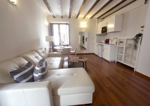 a living room with a white couch and a kitchen at ISA Granada in Granada